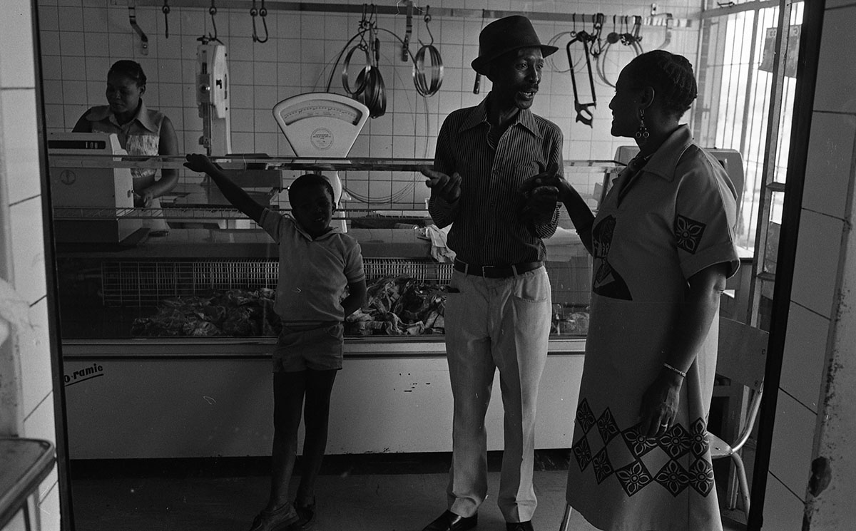 Black and white image of people at counter in shop